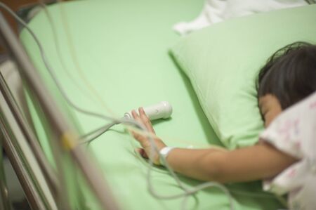 One child is pressing the emergency button, signaling for help from the medical team.の写真素材