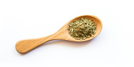 Green Herbal Seasoning In Wooden Spoon On White Background. Dry Basil, Spice Condiment. Top View Of Herbal Ingredient. Natural Dry Condiment.の素材