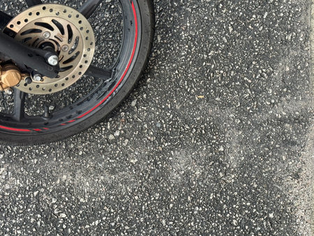 Close up of motorcycle wheel and brake disc on the asphalt road.