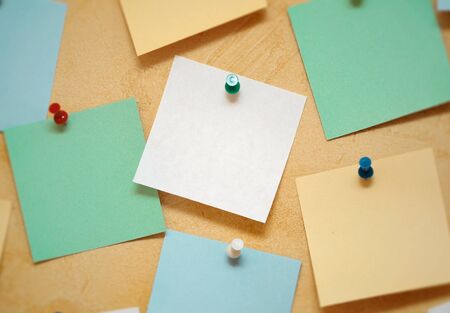 color sheets of paper for notes pinned by pins on the wall