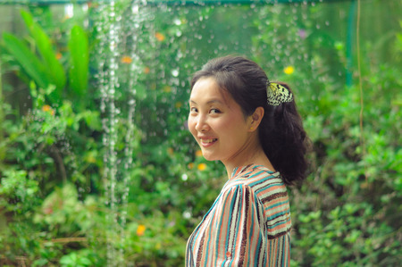 Portrait of single young girl smiling at camera with a white butterfly clings to her hair in a garden  Shot in Butterfly Valley, Bohol, Philippines の写真素材