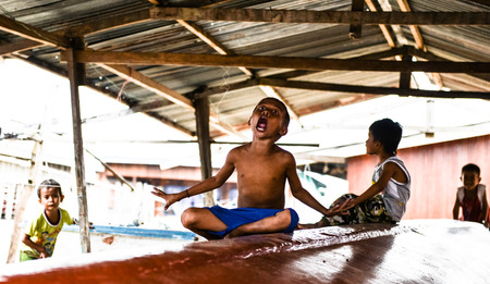 Semporna, Malaysia - Oct 2, 2014    A group of poor little Bajau boys having funs in front of camera on street, shot on Mabul island, Semporna, Sabah, Maylaysia  Bajau people are also referenced as the last sea gypsies,  sea-oriented, boat-dwelling, nomadのeditorial素材