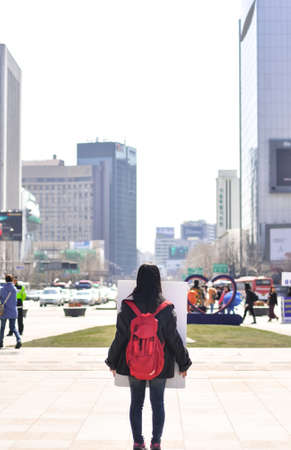  SEOUL, KOREA - APR 7, 2012    a young girl stands in the city alone, holding politician s portrait to help in 2012 Korea president electionのeditorial素材