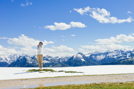 Single young Asian woman standing at edge of Schafberg mountain  , Austriaの写真素材