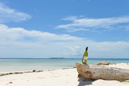 single empty bottle of wine on a lost beach, shot on Mataking island, Semporna, Sabah, Malaysiaの写真素材