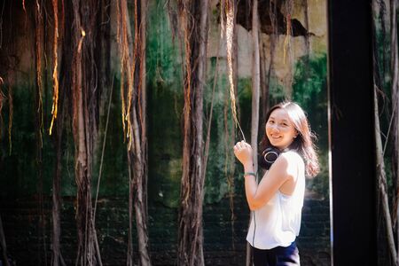 Single young Asian girl smile to camera having fun in old tree house, Anping, Taiwanの写真素材
