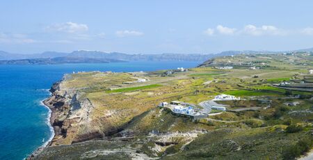 Beautiful landscape of Spring blossoms in Greek village on Santorini grassland by Aeagon seaの写真素材