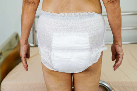 Asian senior woman patient wearing adult incontinence diaper pad in hospital.の写真素材