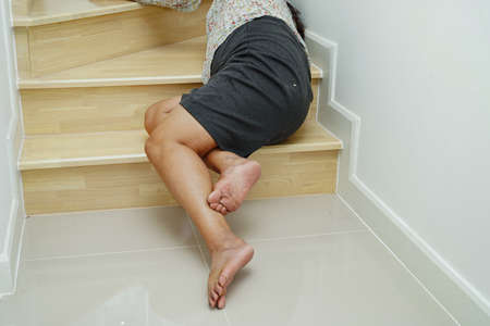 Asian lady woman injuries from falling down on slippery surfaces stairs at home.の写真素材