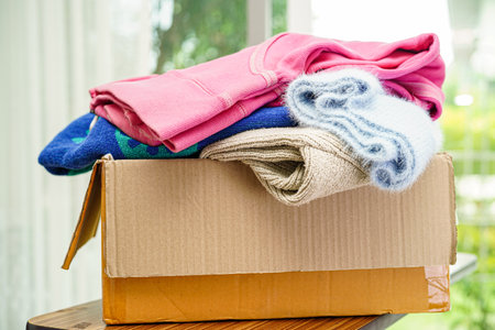 Clothes donations in cardboard box for volunteer.の写真素材
