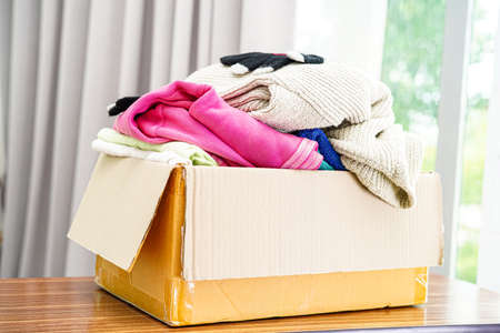 Clothes donations in cardboard box for volunteer.の写真素材