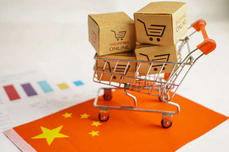 Online shopping, Shopping cart box on business graph and US America flag, import export, finance commerce.の写真素材