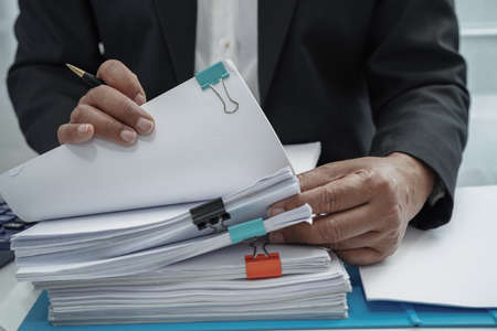 Businessman working and prepare paperwork report data to analysis information in file binder at office.の写真素材