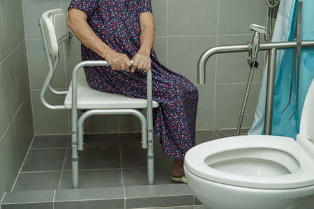 Asian elderly old woman patient use toilet support rail in bathroom, handrail safety grab bar, security in nursing hospital.の写真素材