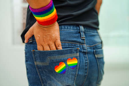 Asian woman with rainbow flag, LGBT symbol rights and gender equality, LGBT Pride Month in June, LGBTQ, LGBTI, LGBTQA, LGBTQIAの写真素材