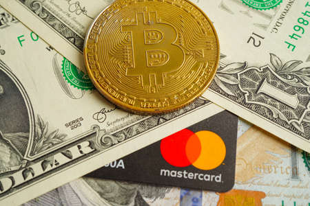 Bangkok, Thailand - December 15, 2021 Golden bitcoin with credit card on US dollar banknotes money for business and commercial, Digital currency, Virtual cryptocurrency.の写真素材