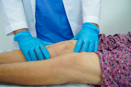 Asian elderly woman patient with scar knee replacement surgery in hospital.の写真素材