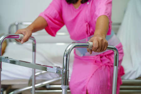 Asian senior pain back wearing elastic support belt with walker.の写真素材