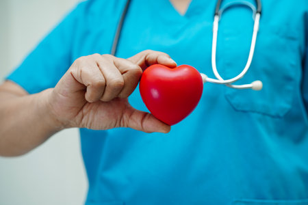 Asian woman doctor holding red heart for health in hospital.の写真素材