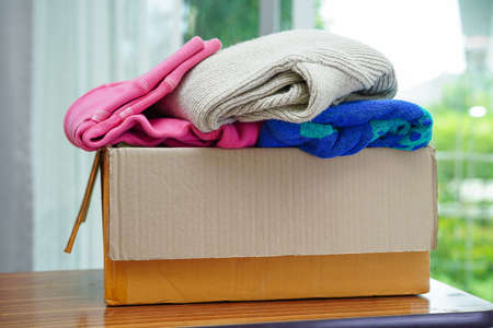 Clothes donations in cardboard box for volunteer.の写真素材