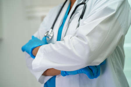 Asian woman doctor holding red heart for health in hospital.