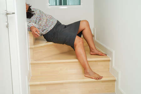 Asian lady woman injuries from falling down on slippery surfaces stairs at home.の写真素材