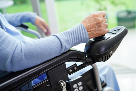 Asian elderly woman disability patient sitting on electric wheelchair in park, medical concept.の写真素材