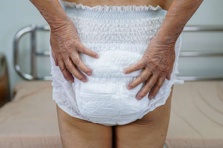 Asian elder senior woman patient wearing adult incontinence diaper pad in hospital.の写真素材