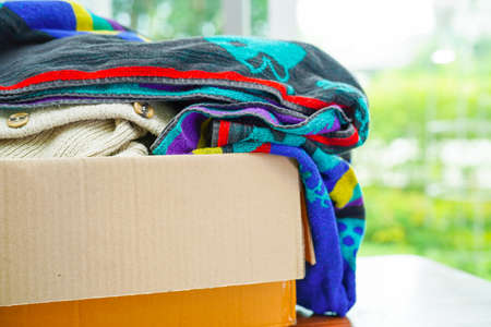 Clothes donations in cardboard box for volunteer.の写真素材