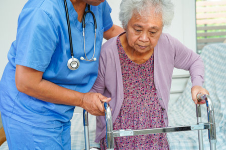 Doctor help Asian elderly woman disability patient in nursing hospital, medical concept.の写真素材
