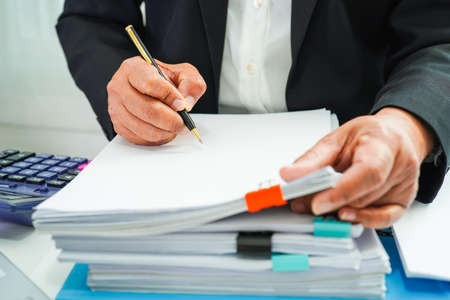 Businessman working and prepare paperwork report data to analysis information in file binder at...