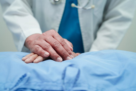 Doctor holding hands Asian elderly woman patient, help and care in hospital.の写真素材