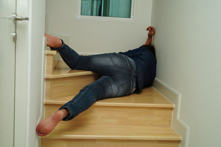 Asian lady woman injuries from falling down on slippery surfaces stairs at home.の写真素材