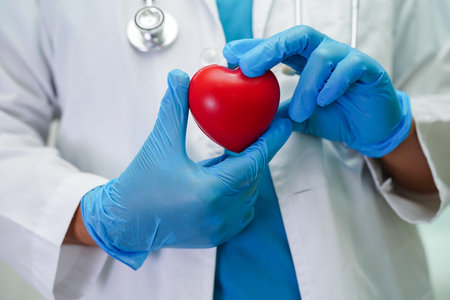 Asian woman doctor holding red heart for health in hospital.の写真素材