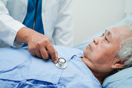 Asia doctor with stethoscope checking elderly woman patient in hospital, healthy medical concept.の写真素材