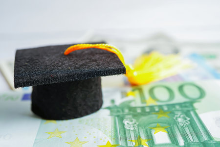 Graduation gap hat on Euro and US dollar banknotes money, Education study fee learning teach concept.の写真素材