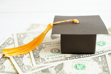 Graduation gap hat on US dollar banknotes money, Education study fee learning teach concept.の写真素材