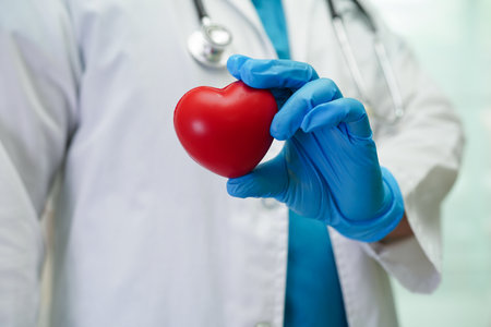Asian woman doctor holding red heart for health in hospital.の写真素材