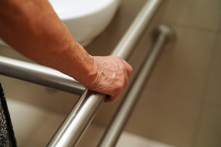 Asian elderly old woman patient use toilet support rail in bathroom, handrail safety grab bar, security in nursing hospital.の写真素材