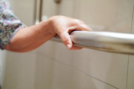 Asian elderly old woman patient use toilet support rail in bathroom, handrail safety grab bar,...