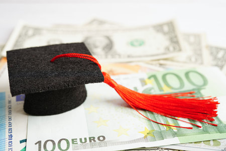 Graduation gap hat on Euro and US dollar banknotes money, Education study fee learning teach concept.の写真素材