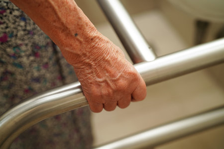 sian elderly old woman patient use toilet support rail in bathroom, handrail safety grab bar, security in nursing hospital.の写真素材