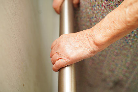 Asian elderly old woman patient use support rail on ramp, handrail safety grab bar, security in nursing hospital.の写真素材