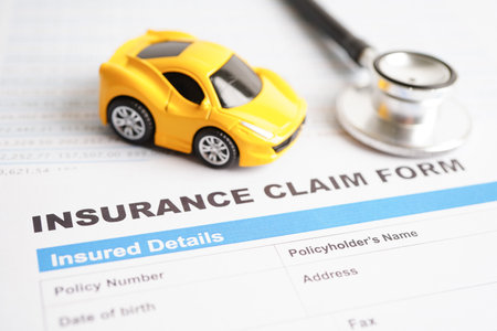 Stethoscope on Insurance claim accident car form, Car loan, insurance and leasing time concepts.の写真素材