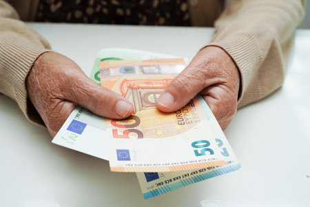 Retired elderly woman holding Euro banknotes money and worry about monthly expenses and treatment...