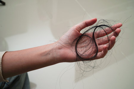 Asian woman have problem with long hair loss attach in her hand.の写真素材