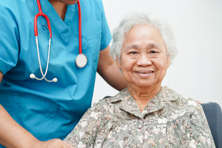 Doctor help Asian elderly woman disability patient sitting on wheelchair in hospital, medical concept.の写真素材