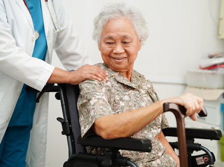 Doctor help Asian elderly woman disability patient sitting on wheelchair in hospital, medical concept.の写真素材