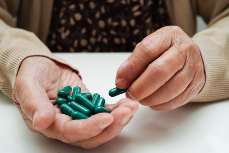 Asian elderly woman holding pill drug in hand, strong healthy medical concept.の写真素材