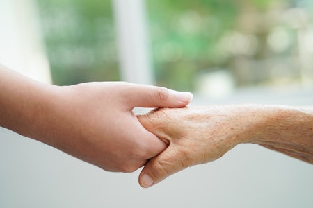 Asian young boy holding old grandmother woman hand together with love and care.の写真素材
